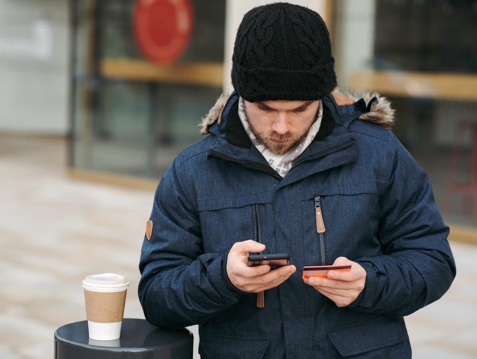 A bank customer uses a mobile phone to perform banking activities.