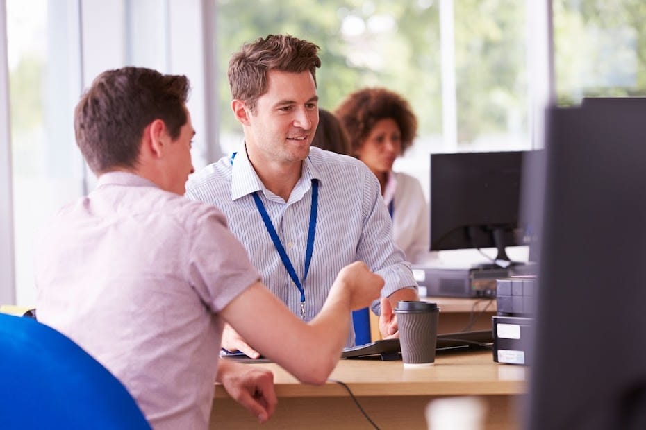 Higher ed administrator and student look at a computer screen together