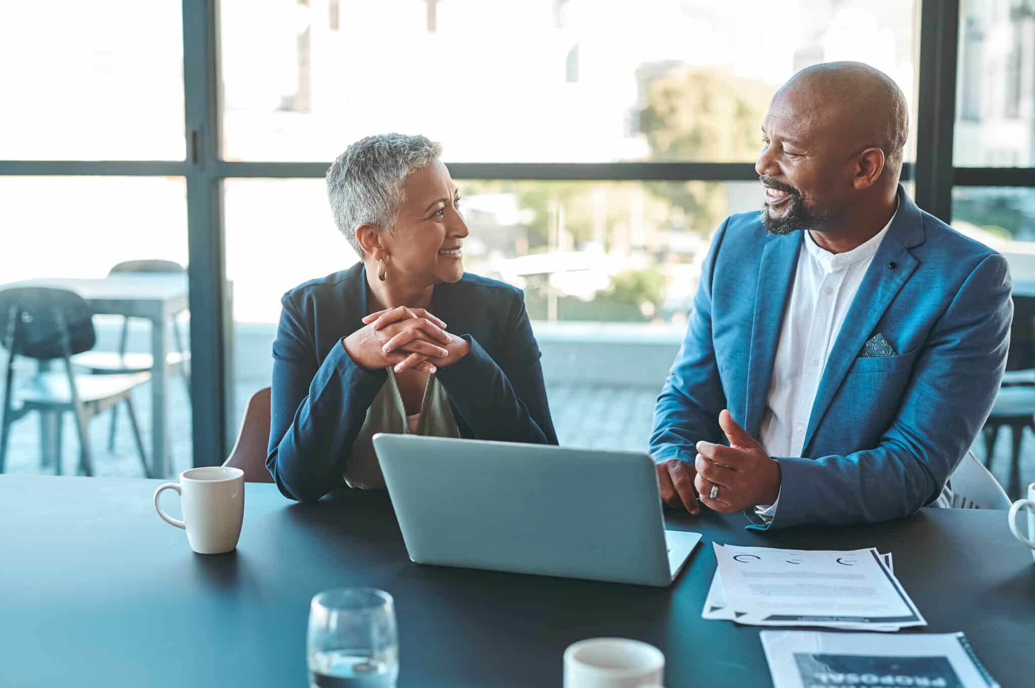 2 financial services professionals chatting in front of a computer