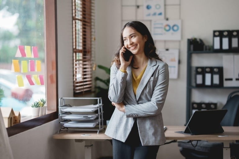 office setting with a woman on the phone showcasing effective cloud communications in a professional environment