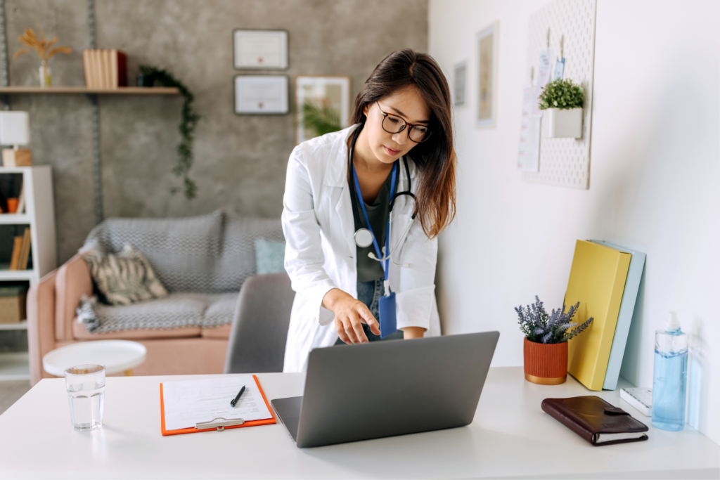 A female doctor reviewing medical records on her laptop